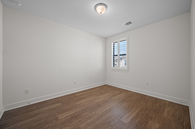 spare room featuring dark wood-type flooring