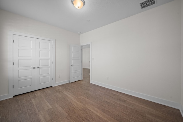 unfurnished bedroom with hardwood / wood-style floors and a closet