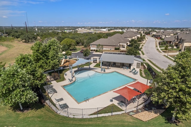 view of pool with a water slide, a lawn, and a patio area