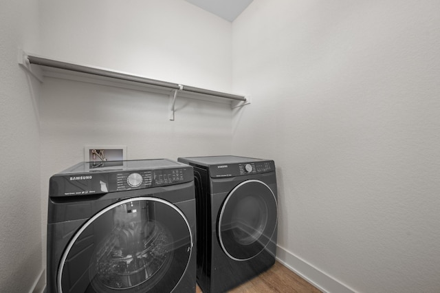 laundry room featuring washing machine and dryer and hardwood / wood-style floors