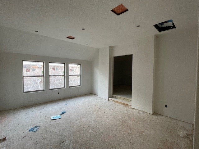 unfurnished room featuring vaulted ceiling