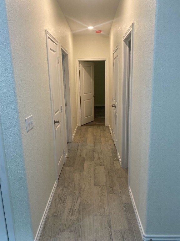 corridor with wood-type flooring