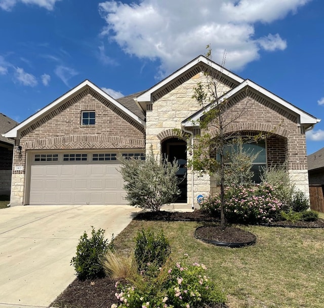 view of front of property featuring a garage and a front lawn