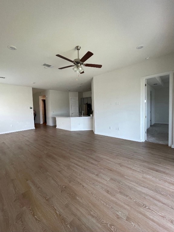 unfurnished living room featuring hardwood / wood-style floors and ceiling fan