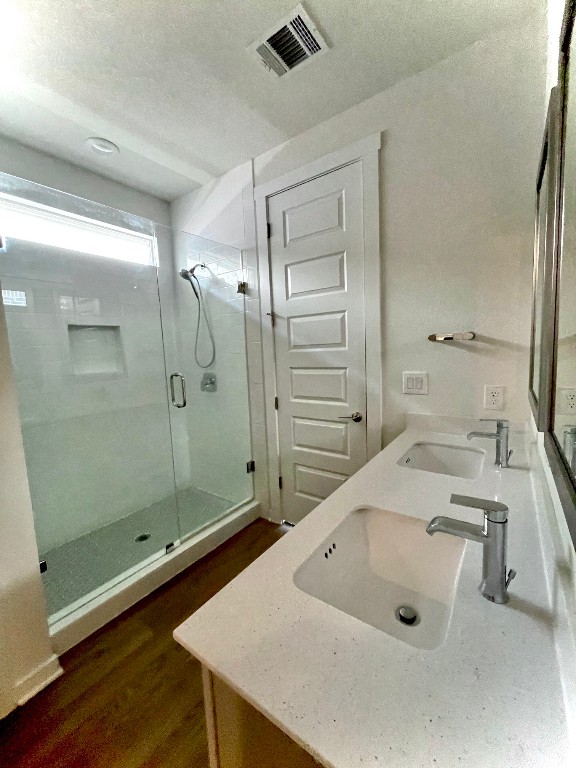 bathroom featuring walk in shower, vanity, and hardwood / wood-style floors