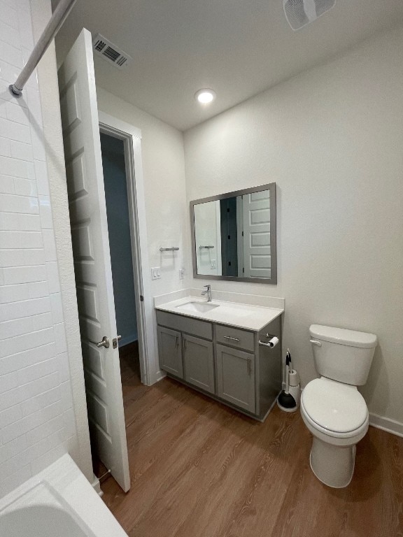 full bathroom with wood-type flooring, vanity, toilet, and shower / washtub combination