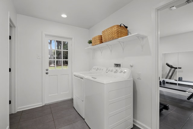 clothes washing area with washing machine and dryer and dark tile patterned flooring