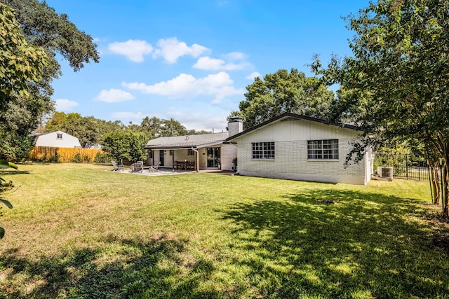 rear view of house featuring a patio area and a lawn