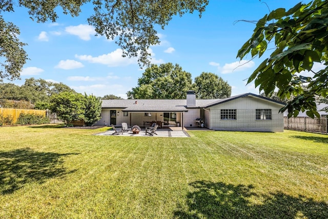 back of property with a patio area and a yard