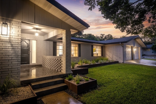 property exterior at dusk featuring a garage and a lawn