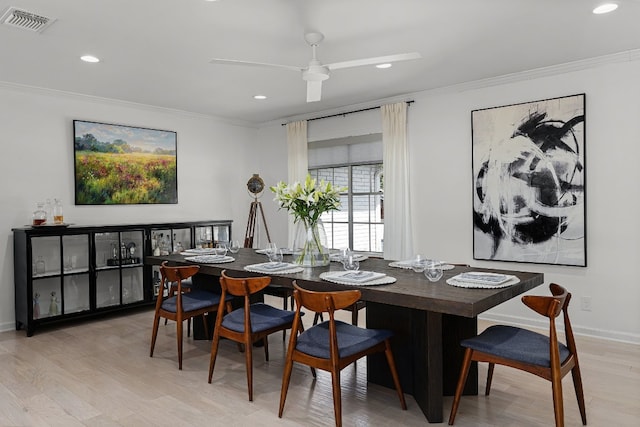 dining space with crown molding, light wood-type flooring, and ceiling fan