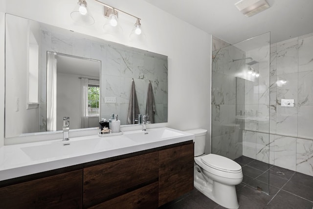 bathroom featuring toilet, vanity, and a tile shower