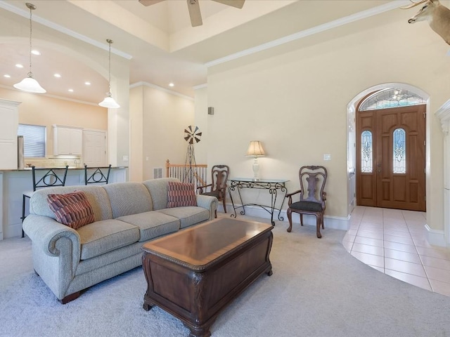 living room with light tile patterned floors, a towering ceiling, ceiling fan, and ornamental molding