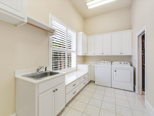 washroom with cabinets, light tile patterned flooring, washer and clothes dryer, and sink