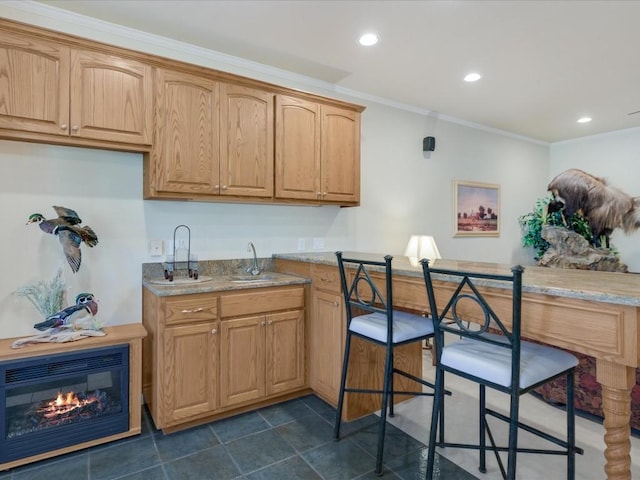 kitchen with light stone counters, sink, and ornamental molding