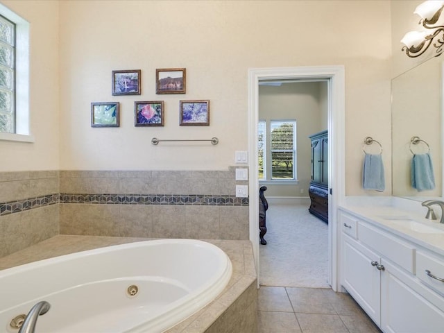 bathroom featuring tiled tub, tile patterned flooring, and vanity