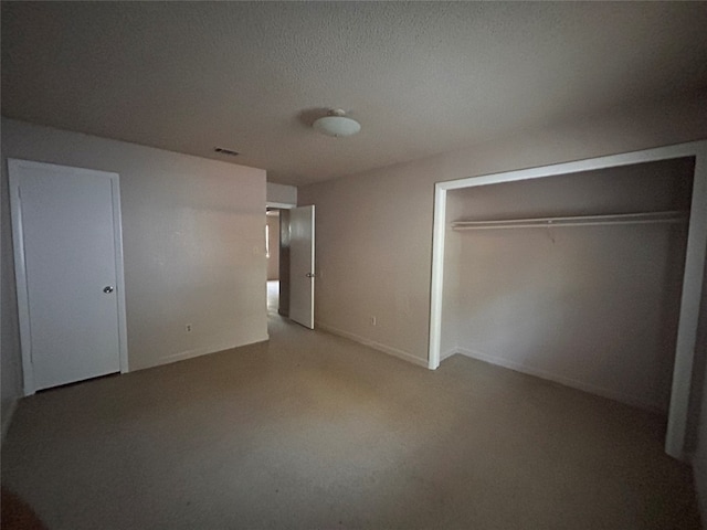 unfurnished bedroom featuring a textured ceiling and a closet