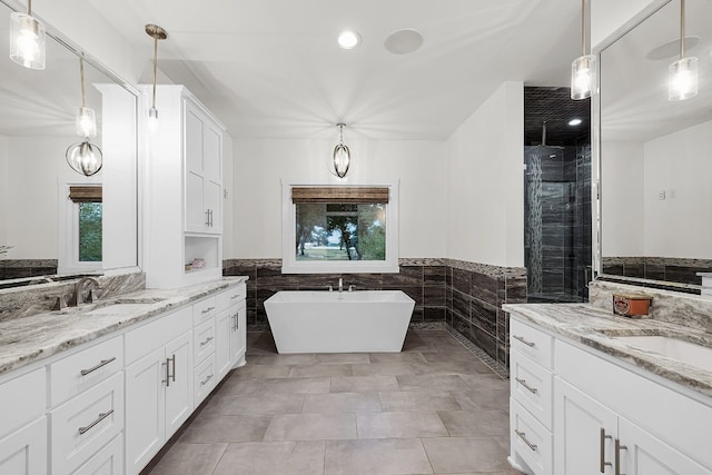 bathroom featuring vanity, independent shower and bath, and a healthy amount of sunlight