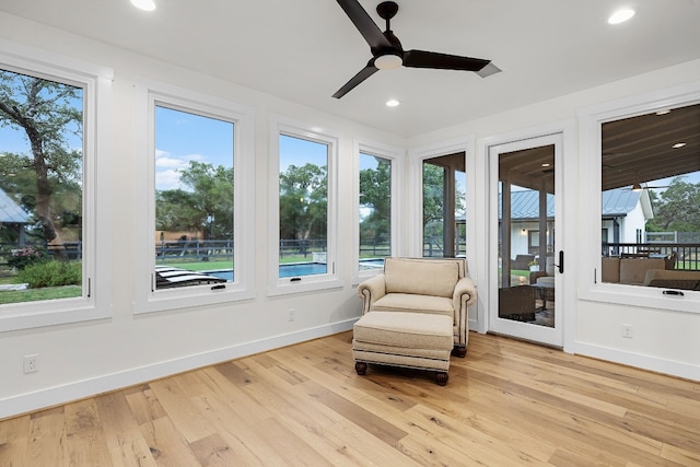 sitting room featuring ceiling fan, light wood-type flooring, and plenty of natural light