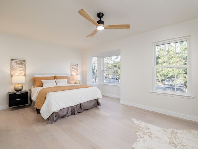 bedroom with ceiling fan and light hardwood / wood-style flooring