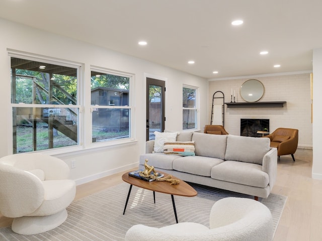 living room featuring light hardwood / wood-style flooring and a brick fireplace