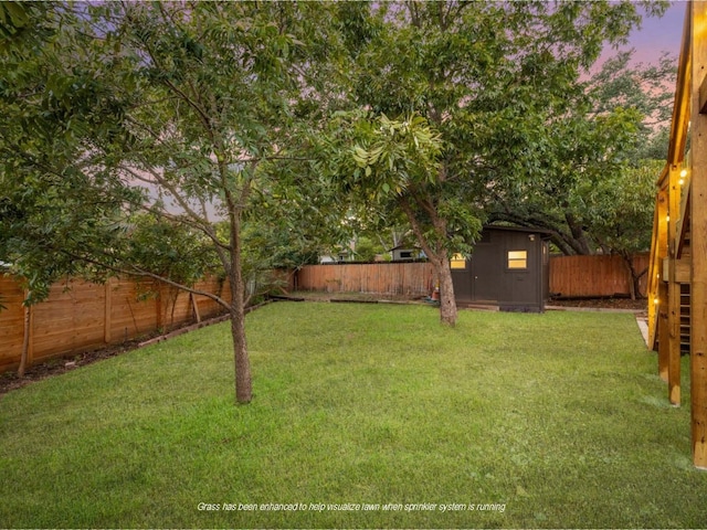 yard at dusk featuring a storage shed