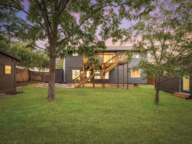 yard at dusk with a patio area and a wooden deck