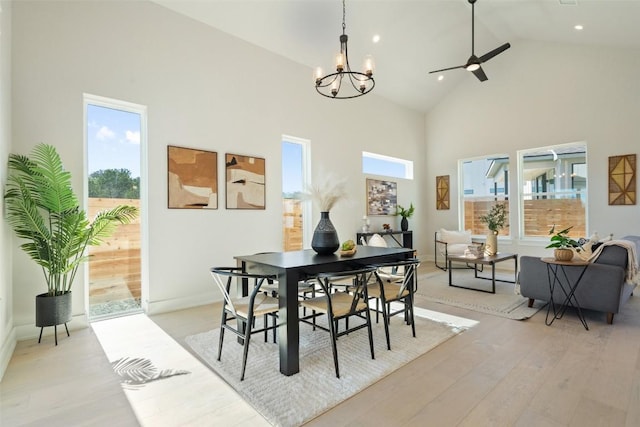 dining room featuring high vaulted ceiling, a wealth of natural light, and light hardwood / wood-style flooring