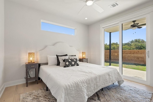 bedroom featuring light wood-type flooring, access to outside, multiple windows, and ceiling fan