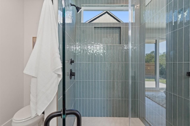 bathroom featuring an enclosed shower, plenty of natural light, and toilet