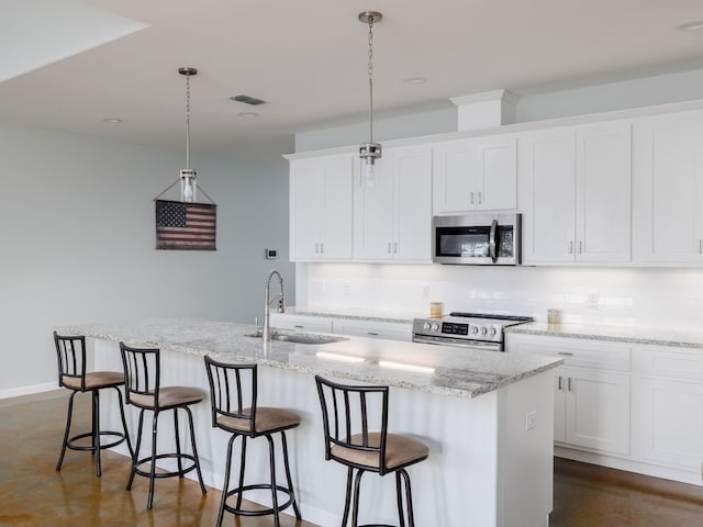 kitchen featuring white cabinetry, a kitchen island with sink, stainless steel appliances, and decorative light fixtures