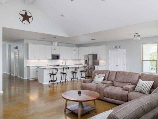 living room with sink, beam ceiling, high vaulted ceiling, and concrete floors