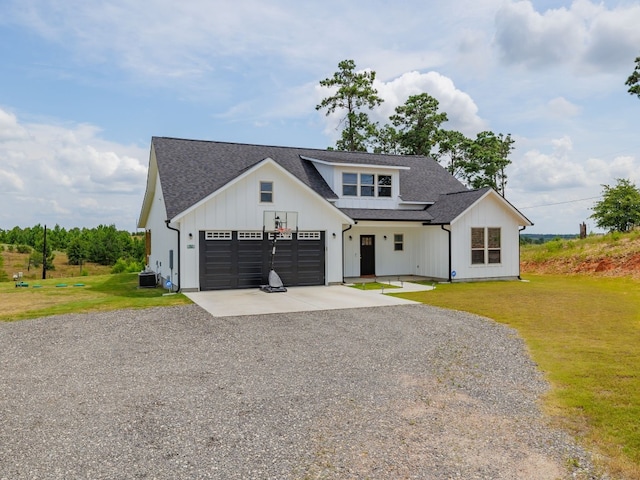 modern farmhouse with a garage, a front lawn, and central air condition unit