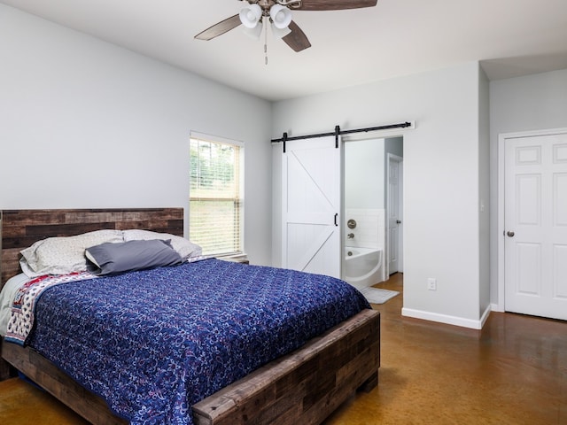 bedroom featuring a barn door, connected bathroom, and ceiling fan