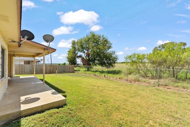 view of yard with ceiling fan and a patio area