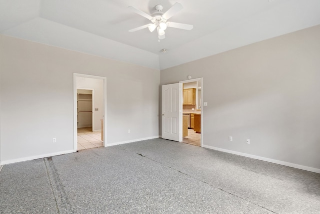 unfurnished bedroom featuring connected bathroom, ceiling fan, and a walk in closet