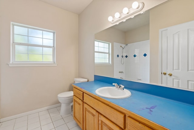 bathroom featuring a tile shower, vanity, toilet, and plenty of natural light