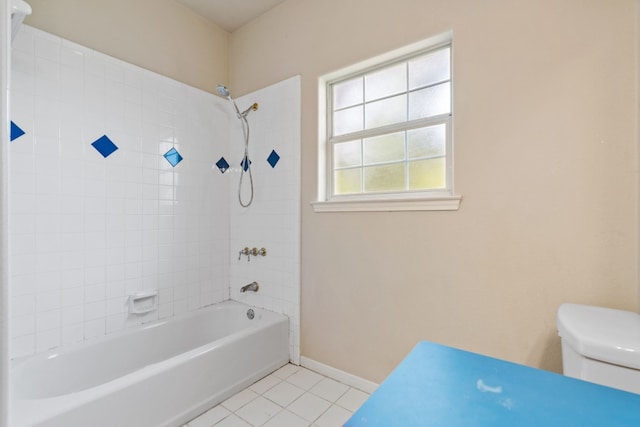 bathroom with tiled shower / bath combo, tile patterned flooring, and toilet