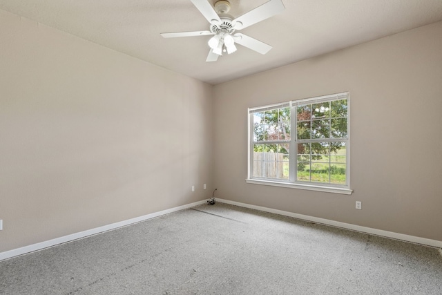 carpeted spare room featuring ceiling fan