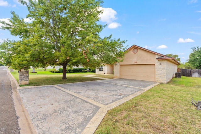 view of front of property with a garage, central AC, and a front yard