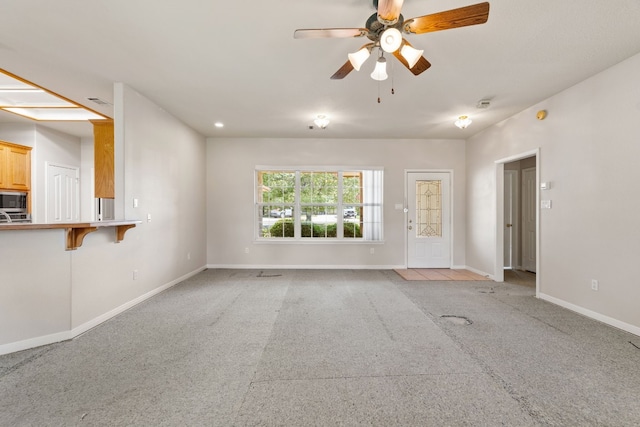 unfurnished living room with ceiling fan and light carpet