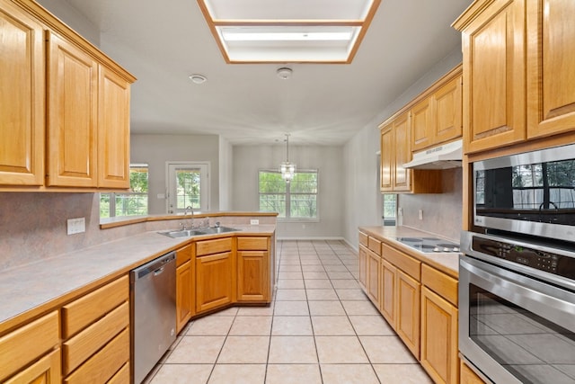 kitchen featuring pendant lighting, sink, decorative backsplash, stainless steel appliances, and light tile patterned floors