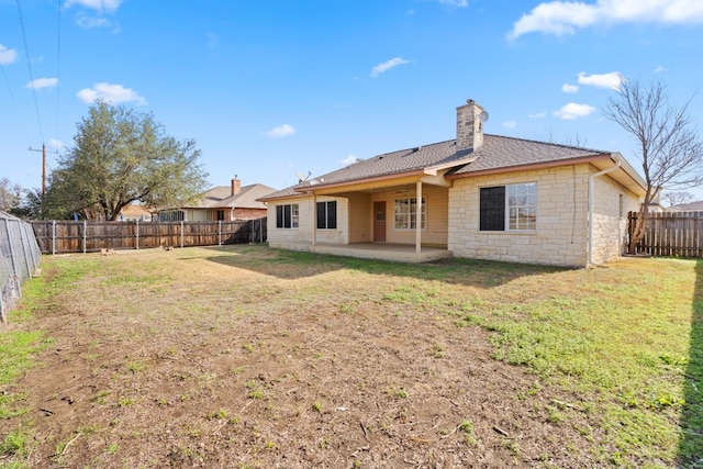 rear view of house featuring a lawn and a patio