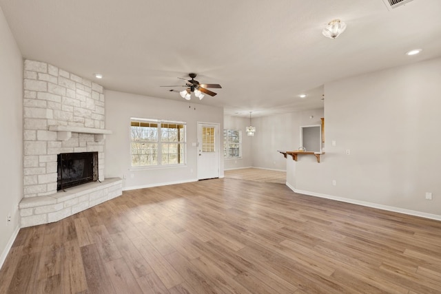 unfurnished living room with hardwood / wood-style flooring, a fireplace, and ceiling fan