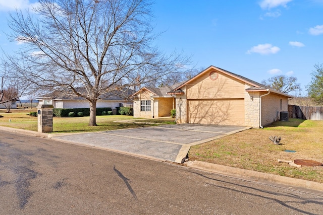 ranch-style house featuring a garage, central AC, and a front yard