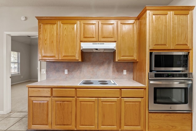 kitchen featuring light tile patterned flooring, appliances with stainless steel finishes, and decorative backsplash