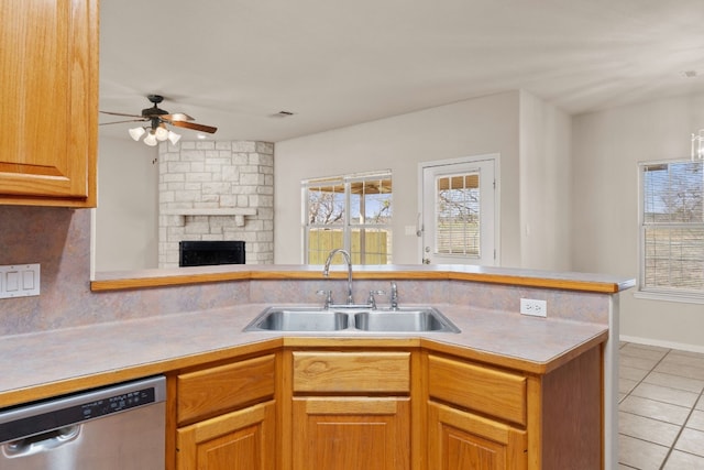 kitchen featuring dishwasher, sink, light tile patterned floors, ceiling fan, and kitchen peninsula