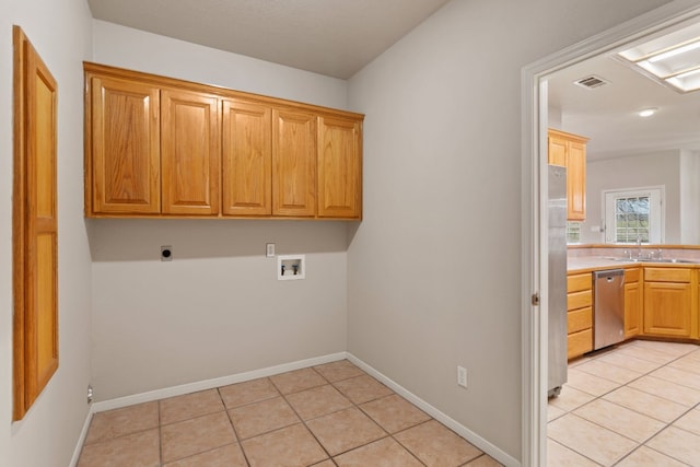 laundry area with electric dryer hookup, light tile patterned floors, hookup for a washing machine, and cabinets