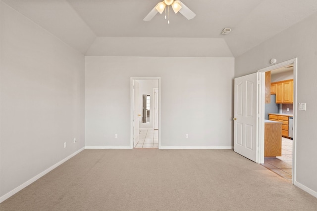 unfurnished bedroom featuring ensuite bathroom, lofted ceiling, and light colored carpet