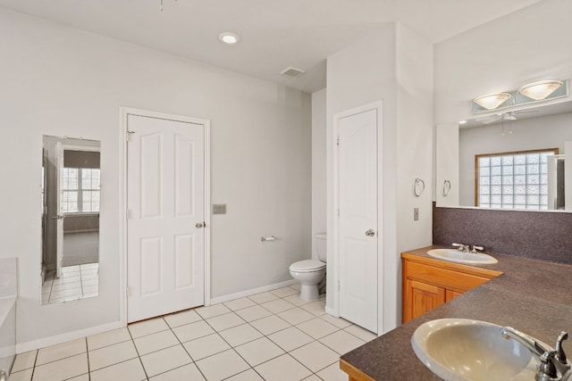 bathroom with vanity, a healthy amount of sunlight, tile patterned floors, and toilet